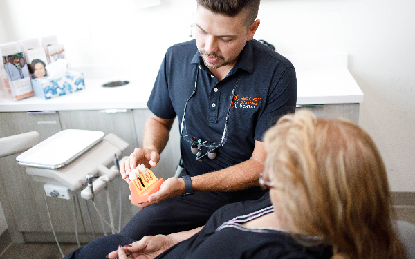A Regency Square Dental dentist walking a patient through a smile design on a dental model.